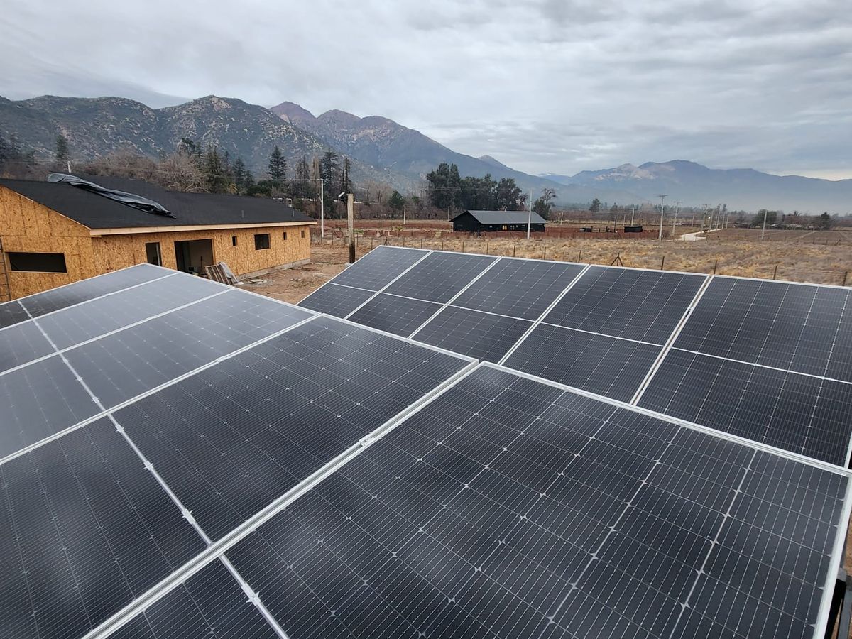 Paneles solares sobre contenedor con vista a la cordillera en Pirque
