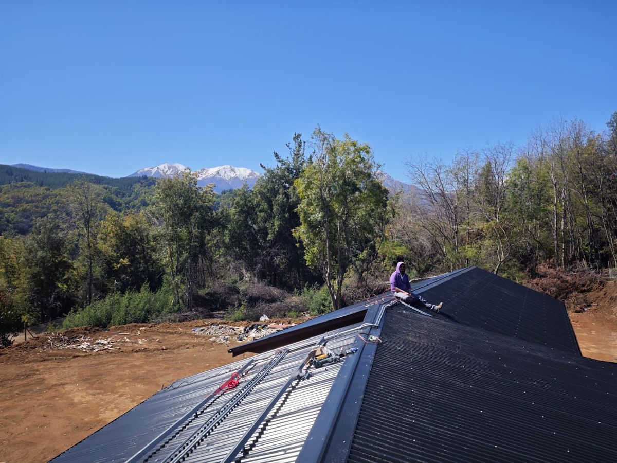 Instalación de paneles solares en techo con cordillera nevada en Vilches